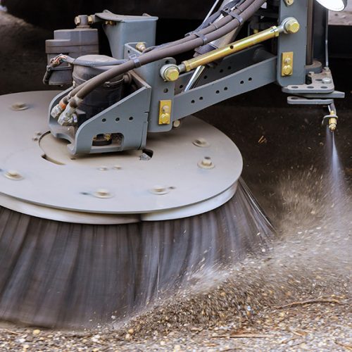 Street sweeper machine cleaning the streets in utility service on the town.